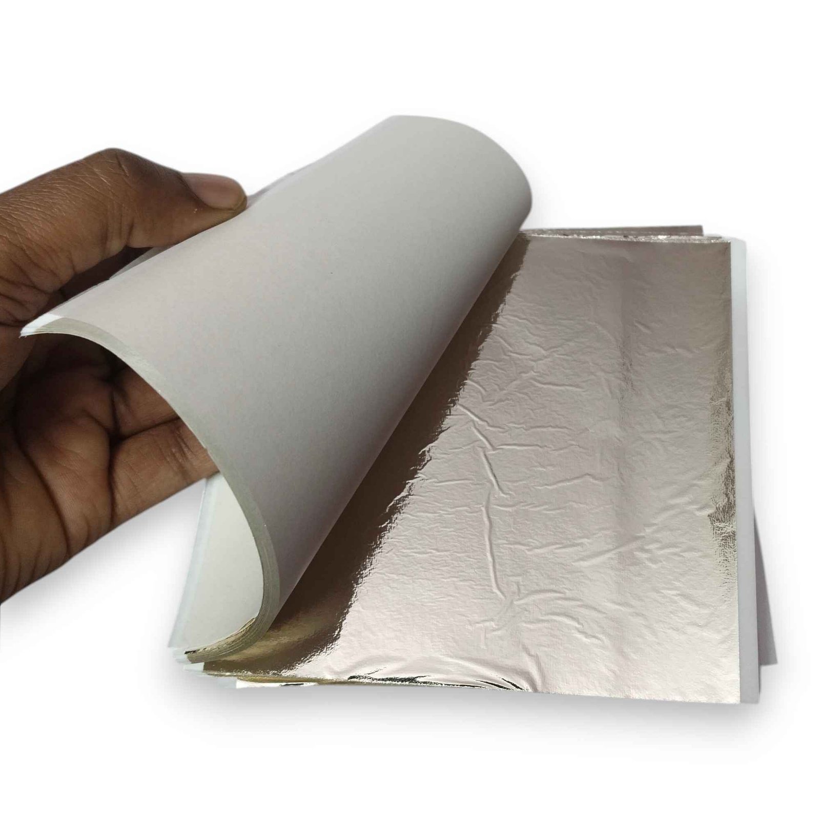 Stack of light champagne silver foil sheets in Sumera Warq packaging