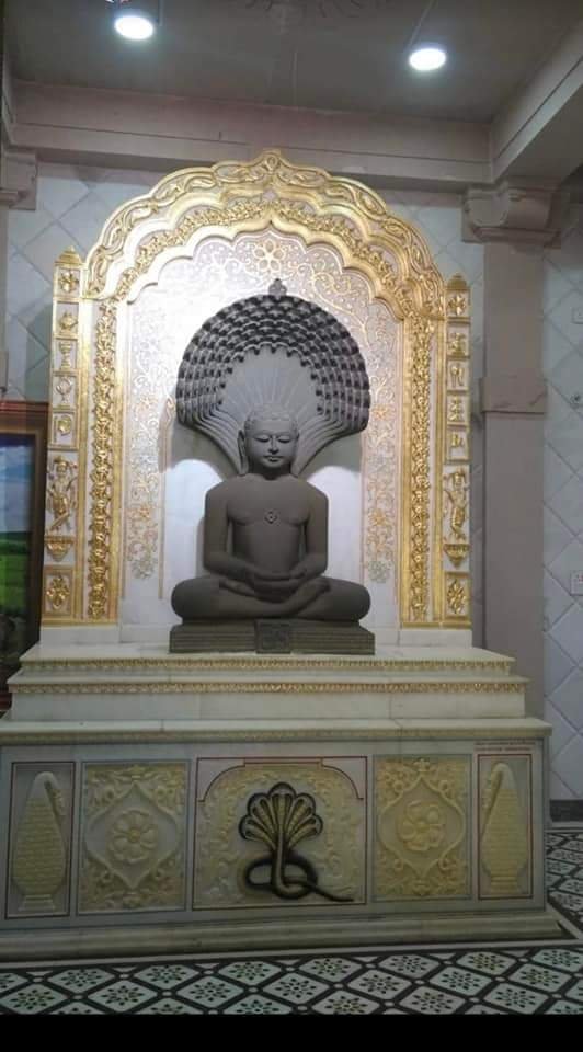 Gold leafing on carved arch frame around Parshvanath murti