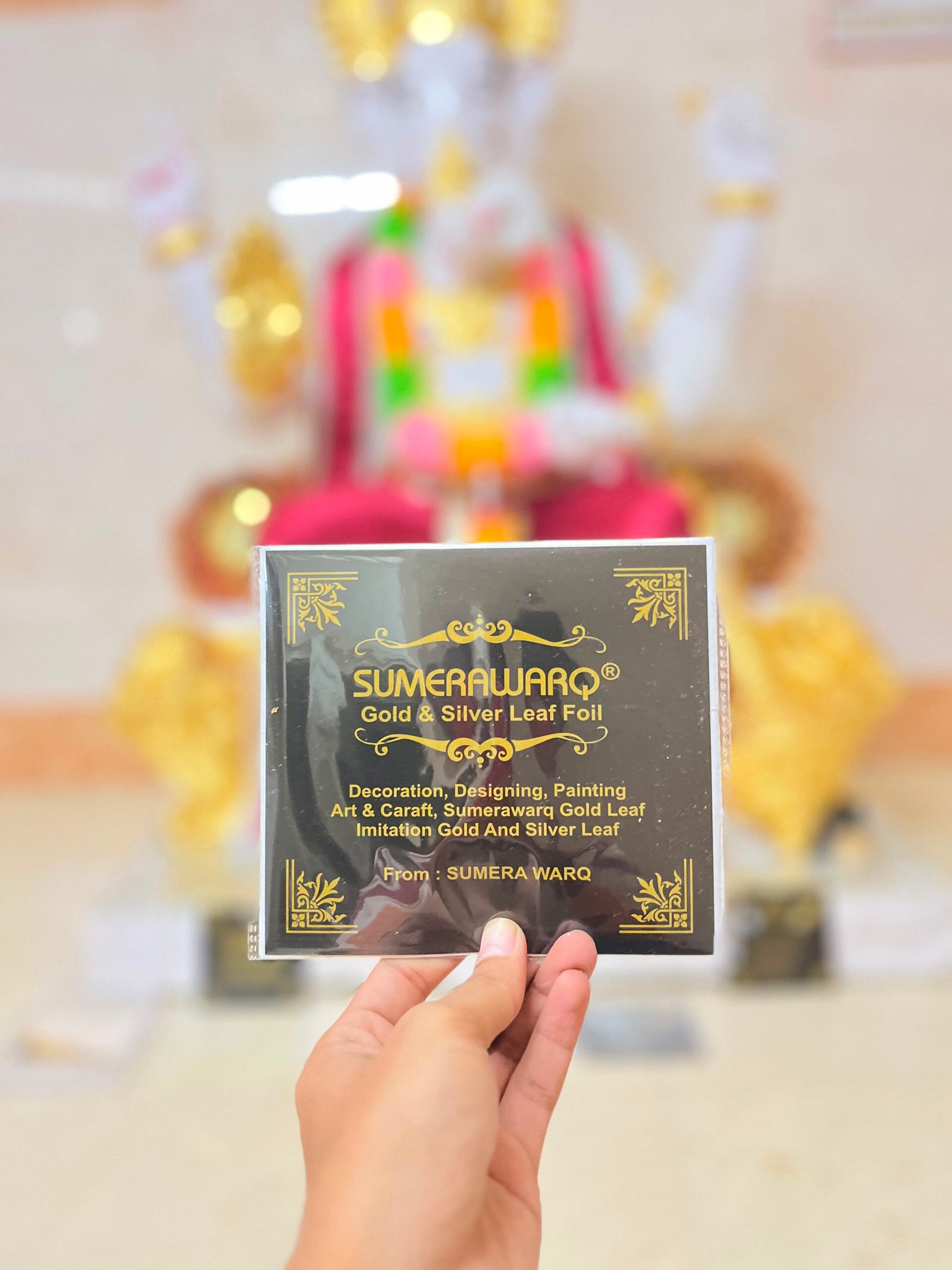 Sumera Warq imitation gold leaf packet murti ke saamne