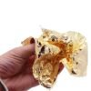 Gold leaf foil sheet held crumpled in hand showing thinness