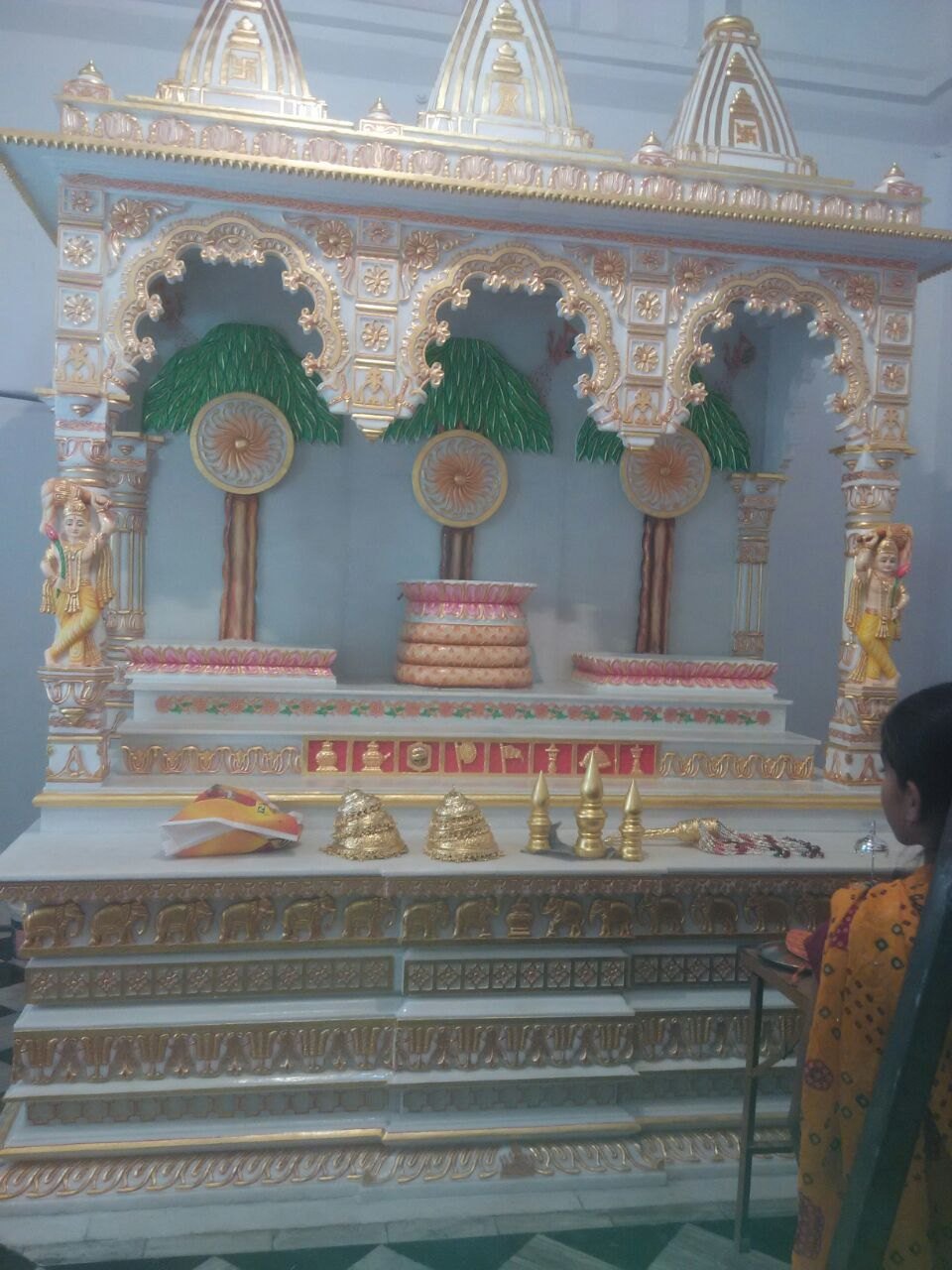 White marble mandir vedi with gold leafed shikhar and carved elephants