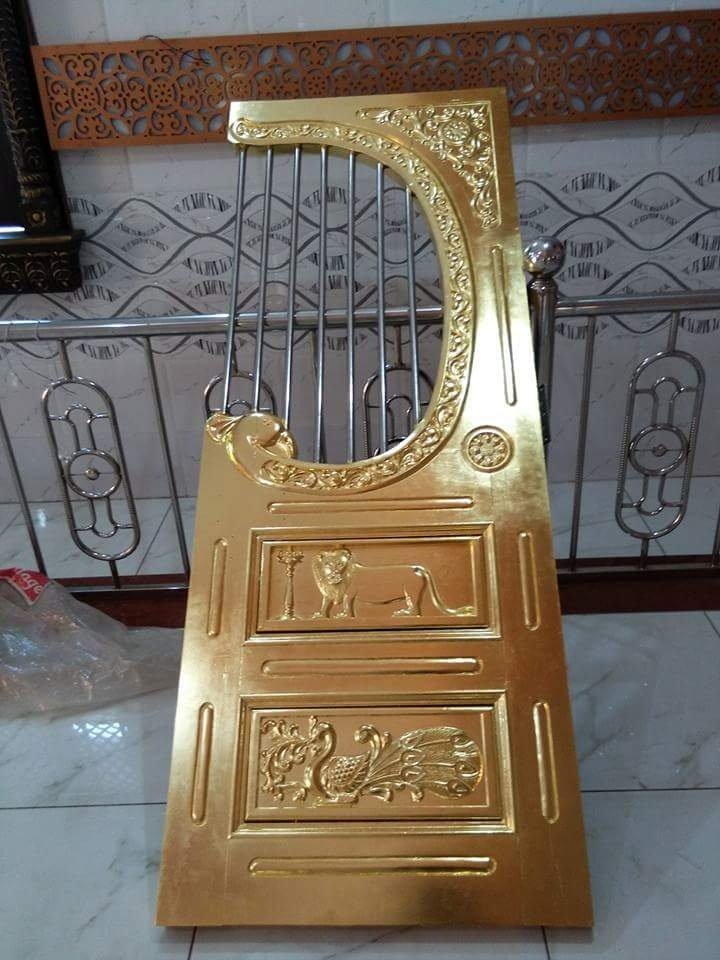 Carved wooden door panel finished in gold leaf with peacock and lion motifs