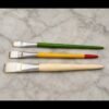 Three flat gilding brushes for gold leaf and varak work displayed on marble surface